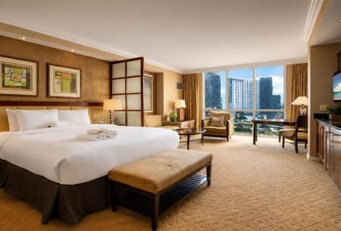 King Suite — 32nd Floor primary bedroom with private ensuite bath, blackout drapes, and open city views