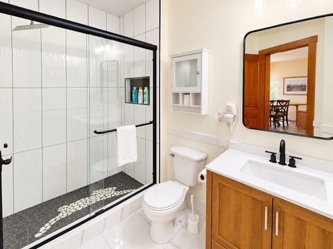 Crisp, renovated bath with glass shower and modern vanity.