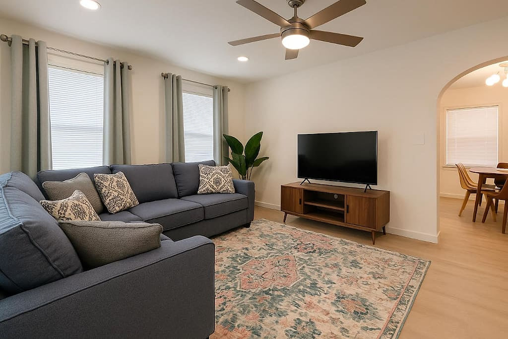 Cozy up in the inviting front living room, where a plush sectional, smart TV, and warm natural light create the perfect place to relax.