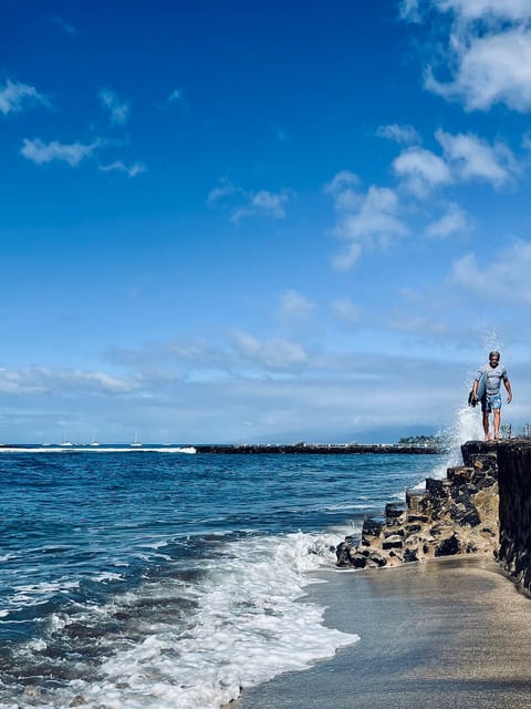A surfer is returning from their morning session by the harbor (yes there are lessons available on site, Bully’s).