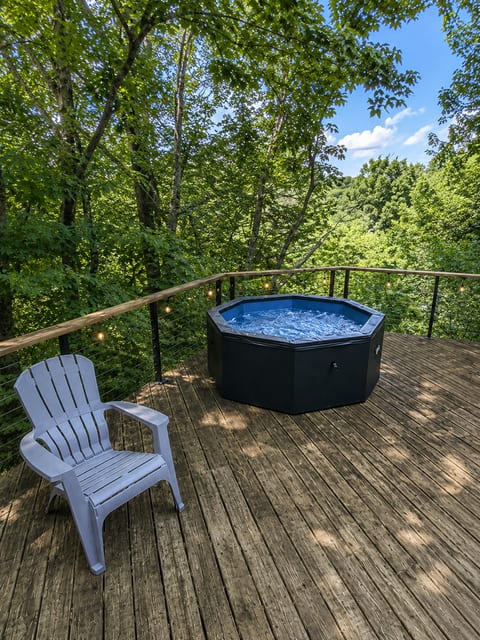 Enjoy the ultimate outdoor experience with our private hot tub and cozy seating area, perfectly nestled in the trees for a peaceful, nature-filled escape.