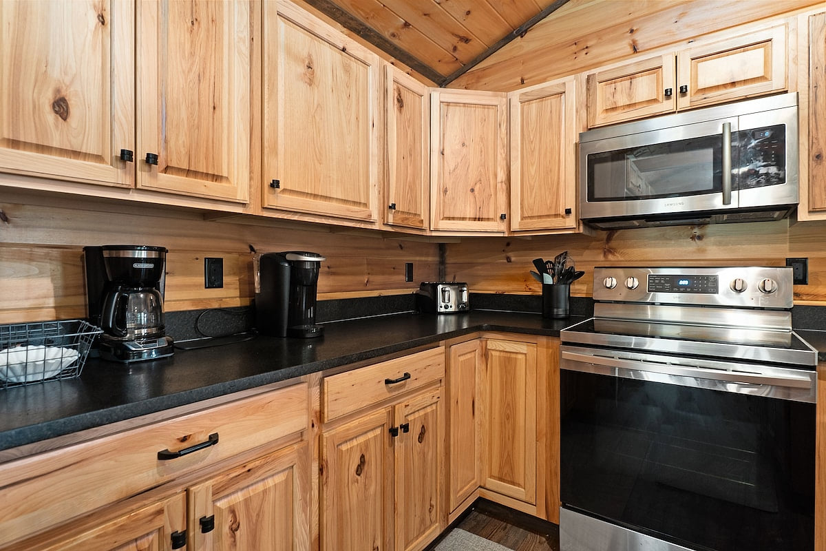 Kitchen stocked with Kurig and drip coffee makers, toaster, electric kettle, cooking and eating utensils, flatware, apices etc.