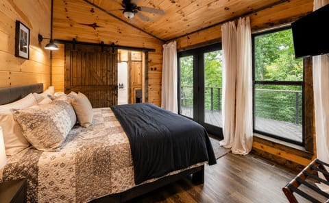 Mountain Modern bedroom with a plush king bed and direct deck access. Step right outside to relax in the private hot tub and take in the serene surroundings.