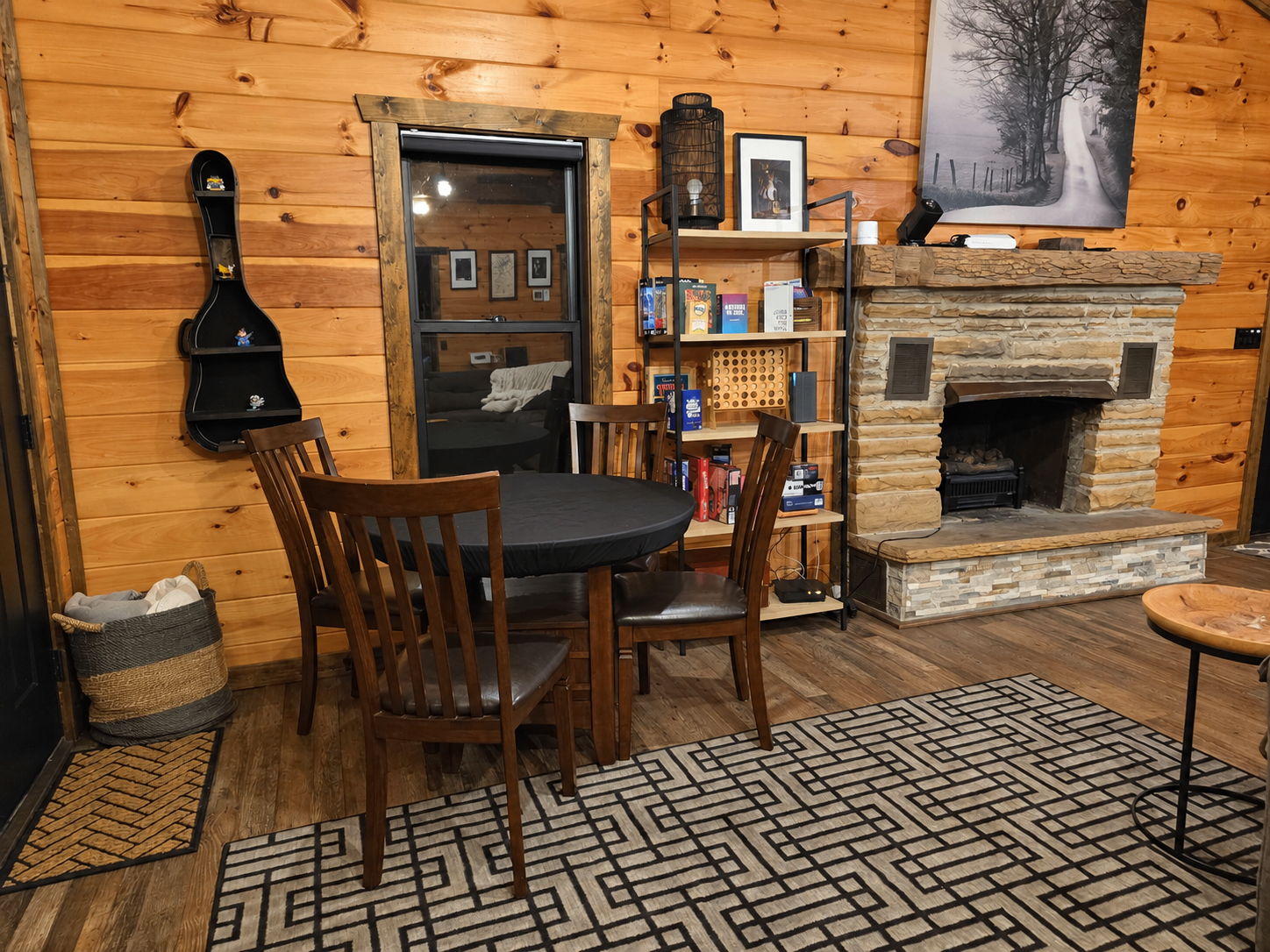 Indoor dining beside the electric fireplace, with books and board games nearby. A cozy spot for meals and an evening in.