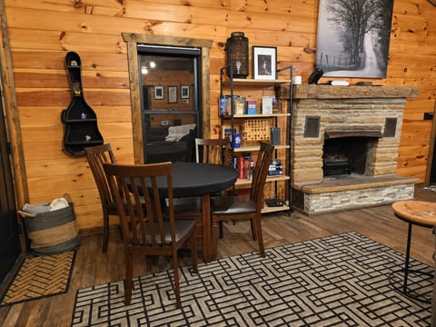 Indoor dining beside the electric fireplace, with books and board games nearby. A cozy spot for meals and an evening in.