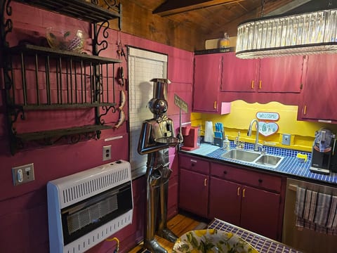 Vibrant fuchsia kitchen with yellow accents and blue tile countertops.
