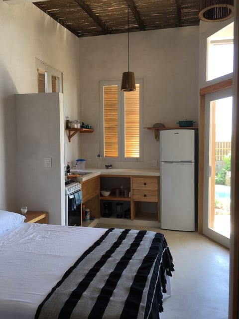 Photo of the cabaña 1 interior that shows the bed and kitchen.