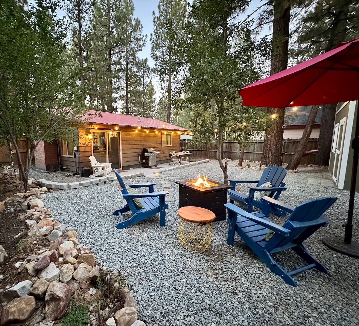 Gather around the fire pit beneath string lights and tall pines for relaxed evenings outdoors. Toast s’mores, share a drink, and enjoy the fresh mountain air in the fenced backyard.