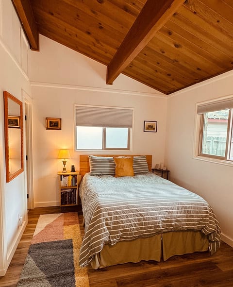 Cozy bedroom with a plush queen bed, foam mattress topper, and plenty of pillows. An oversized comforter keeps you warm on snowy nights, while window shades block light and help retain heat for a private, restful retreat.