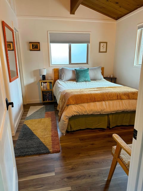 Cozy bedroom with a plush queen bed, foam mattress topper, and plenty of pillows. An oversized comforter keeps you warm on snowy nights, while window shades block light and help retain heat for a private, restful retreat.