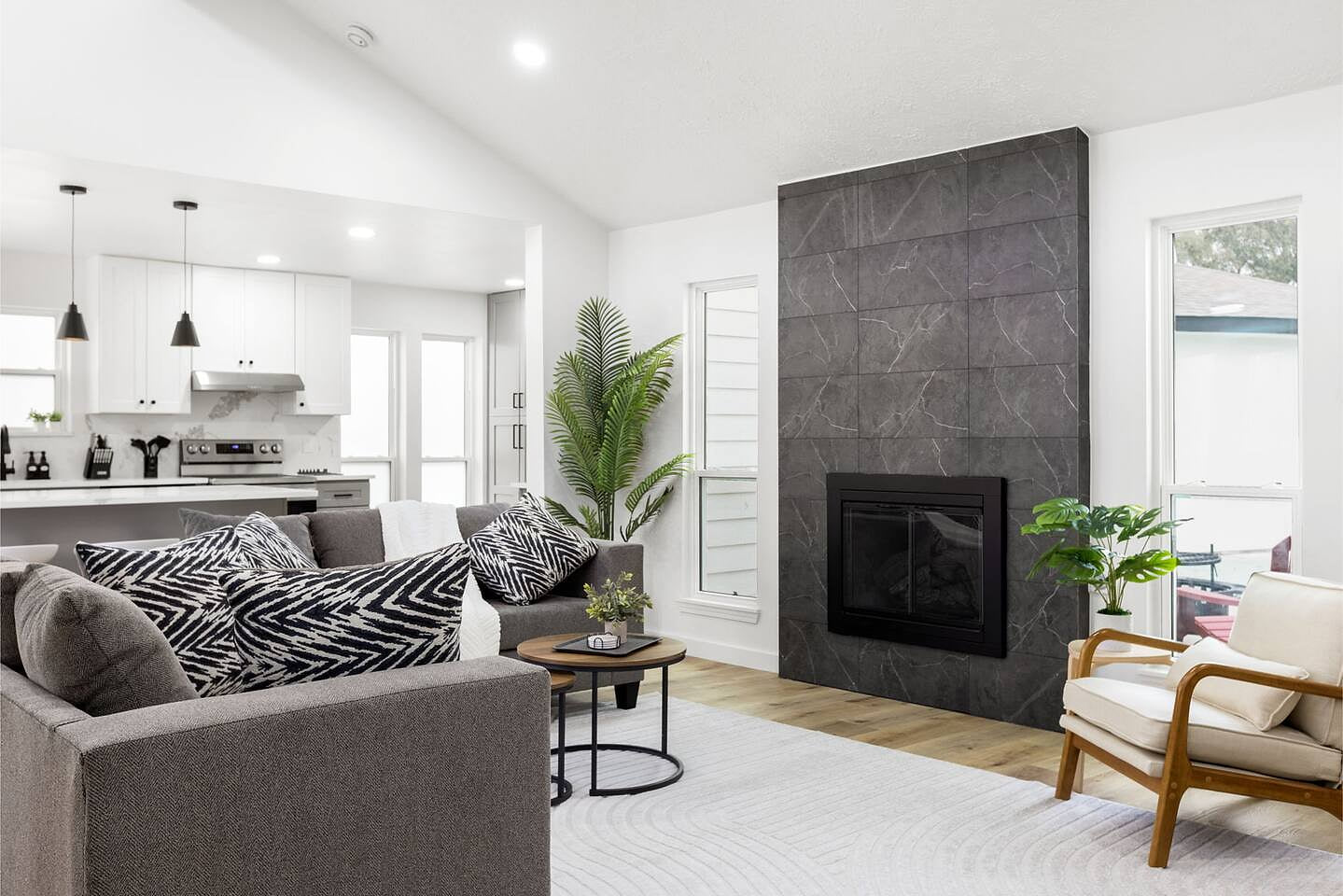 Recently fully remodeled modern living room with a high ceiling. Opens to the white chef’s kitchen on light wood floors—great for relaxing or gatherings