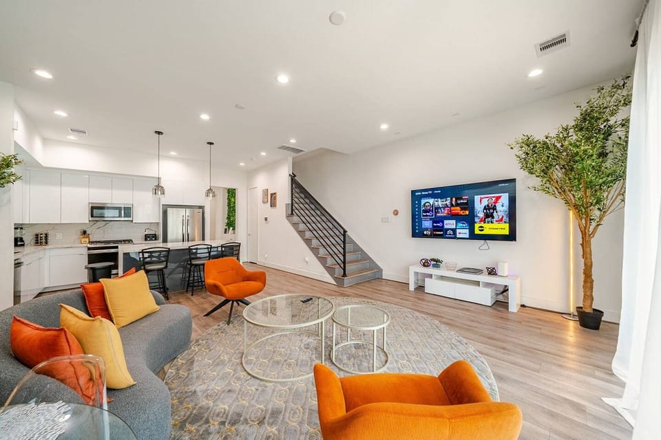 Modern open-plan lounge with smart TV, sleek kitchen, vibrant seating