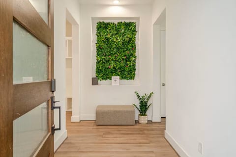 Modern entry with green wall, bench seating, and airy, light-filled style