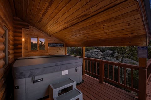 Covered private hot tub deck with cozy cabin charm and forest views