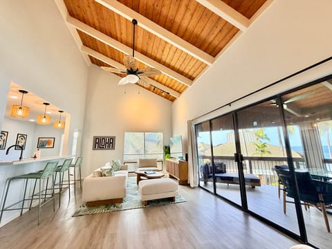 Airy living room with vaulted ceiling and lanai with ocean views