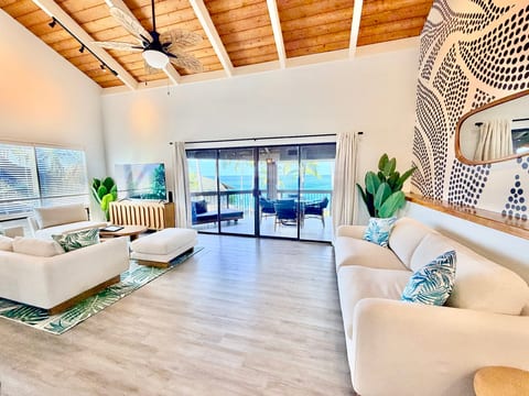 Bright coastal living room with vaulted ceilings and ocean-view lanai, sofa bed is on the right side of photo