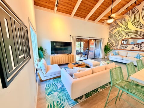 Bright vaulted living room with patio access and stylish tropical design