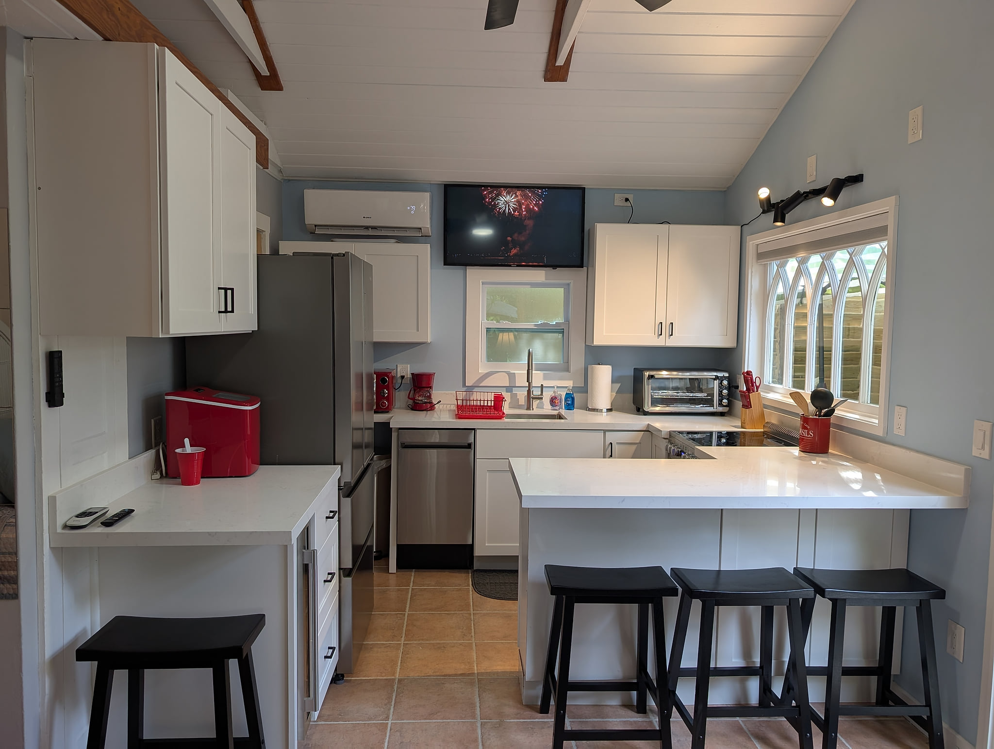 Bright vaulted kitchen with bar seating, stainless appliances, coffee bar.