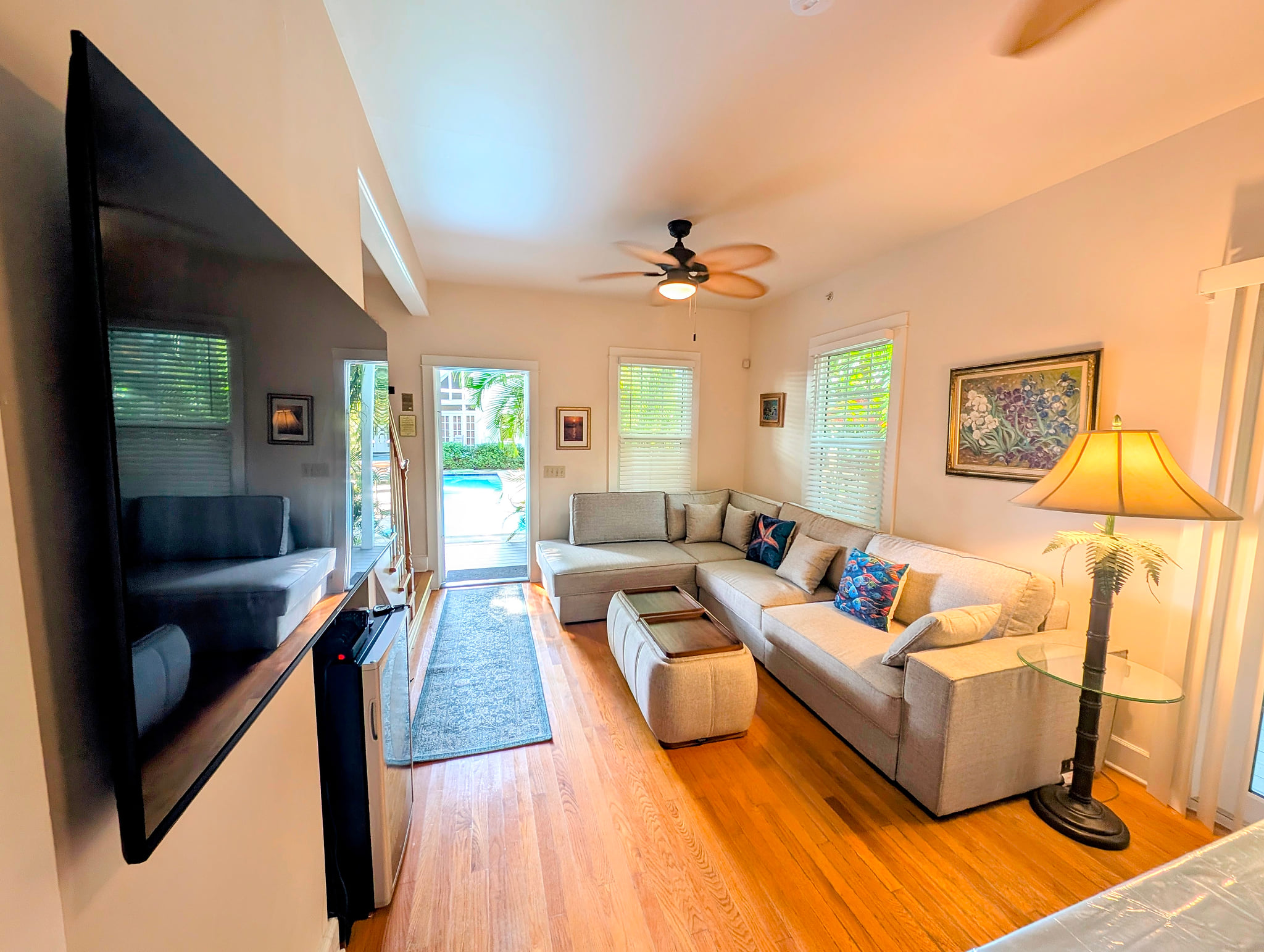 Bright living room with pool access, big TV, comfy sectional sofa