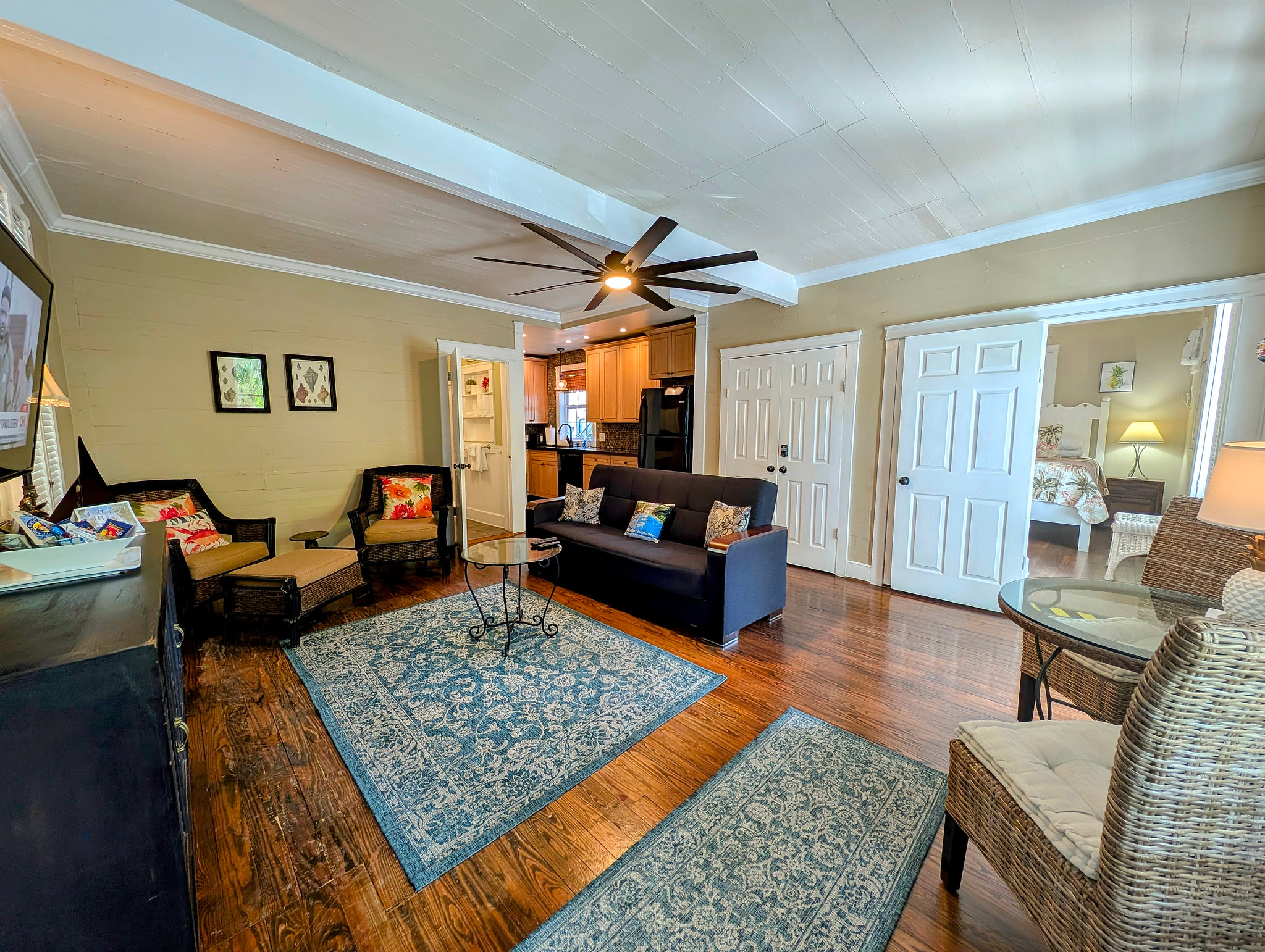 Bright living room with hardwood floors, ceiling fan, and easy kitchen/bedroom access