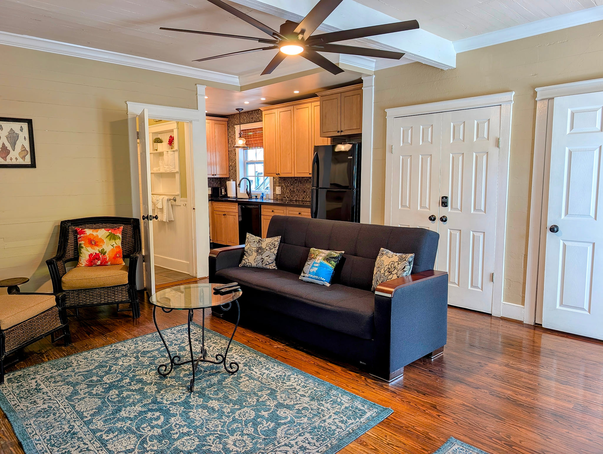 Cozy lounge and open kitchen with hardwood floors and modern finishes