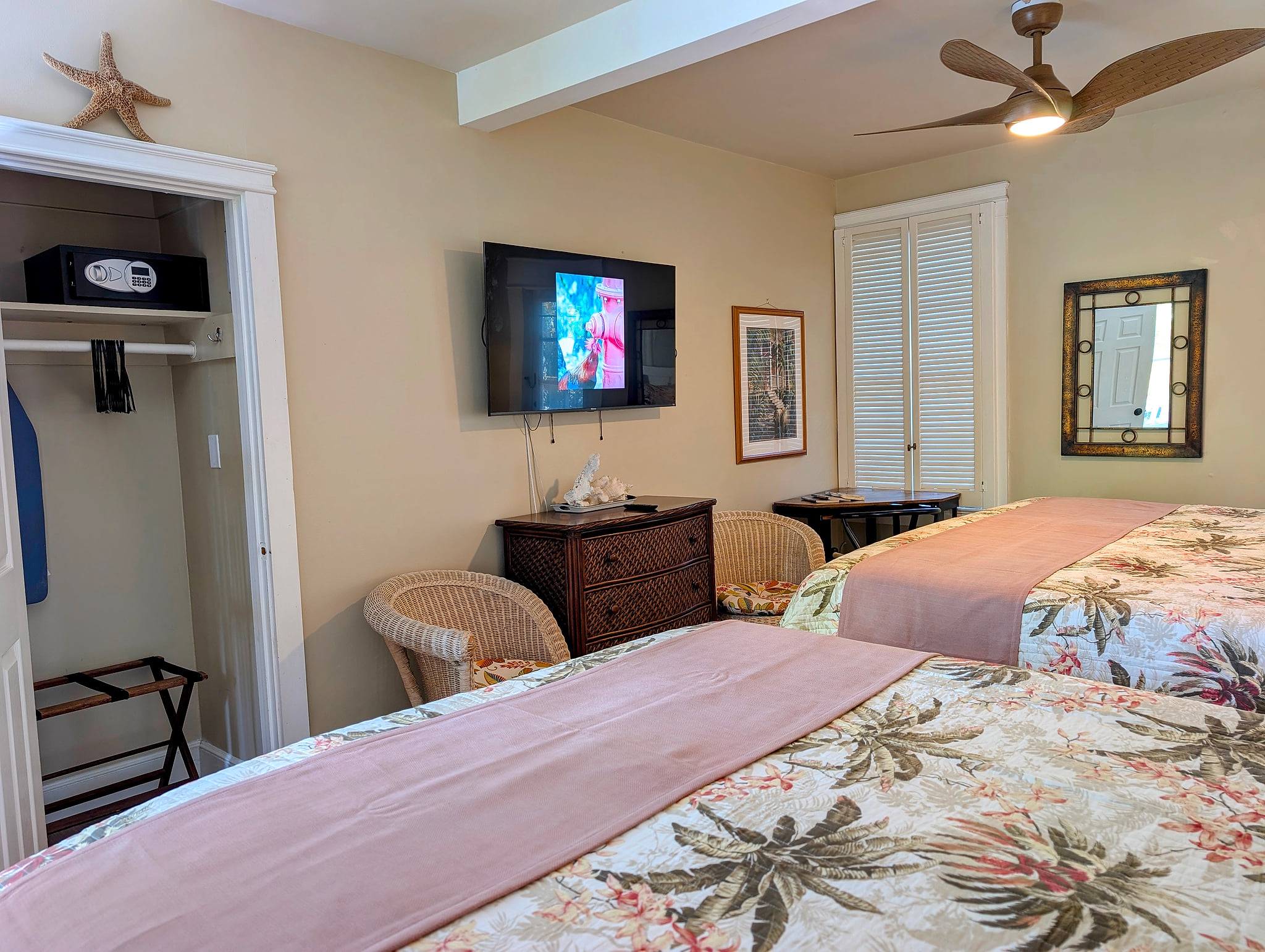 Tropical double-bed room with TV, safe, ceiling fan, and wicker seating