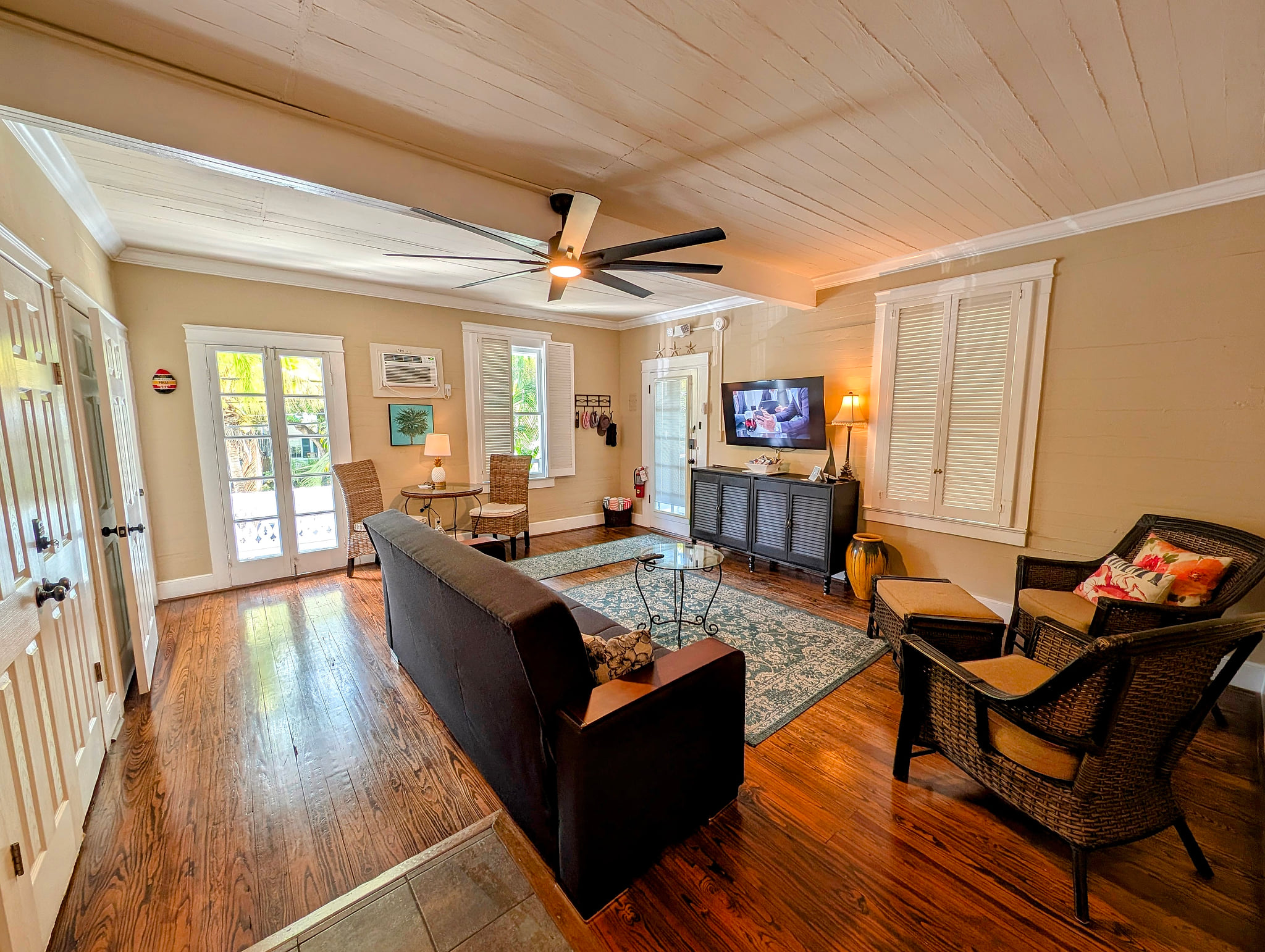 Sunny living room with hardwood floors, smart TV, and porch access