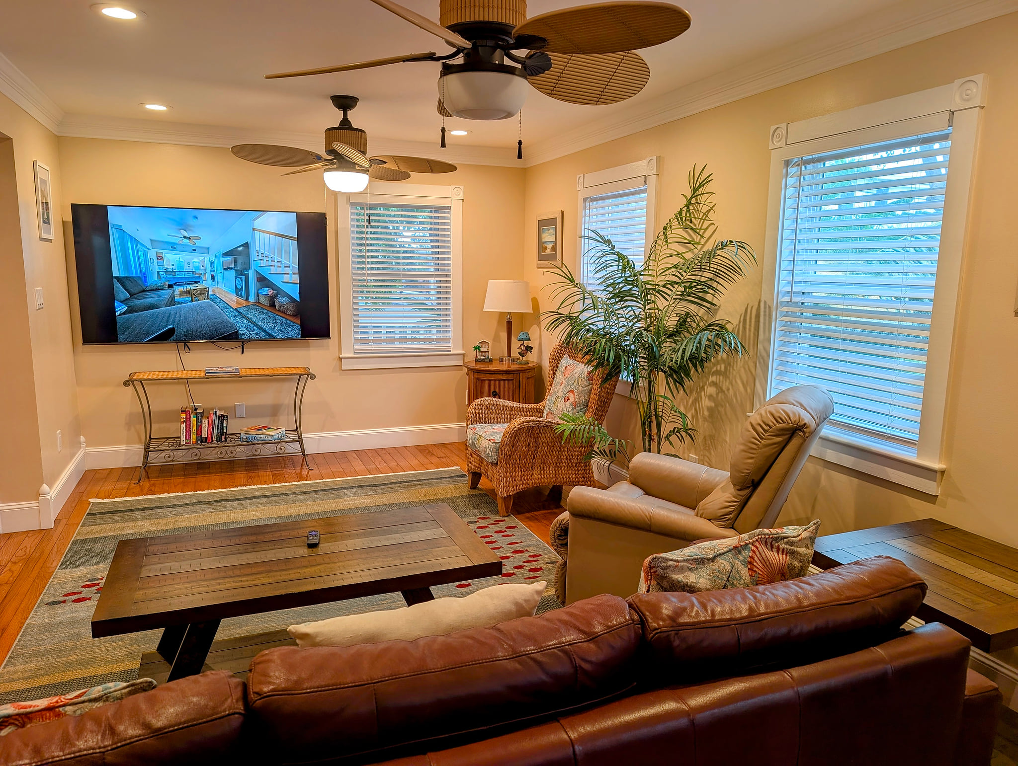 Cozy living room with large 75 inch smart TV, leather sofa, and recliner