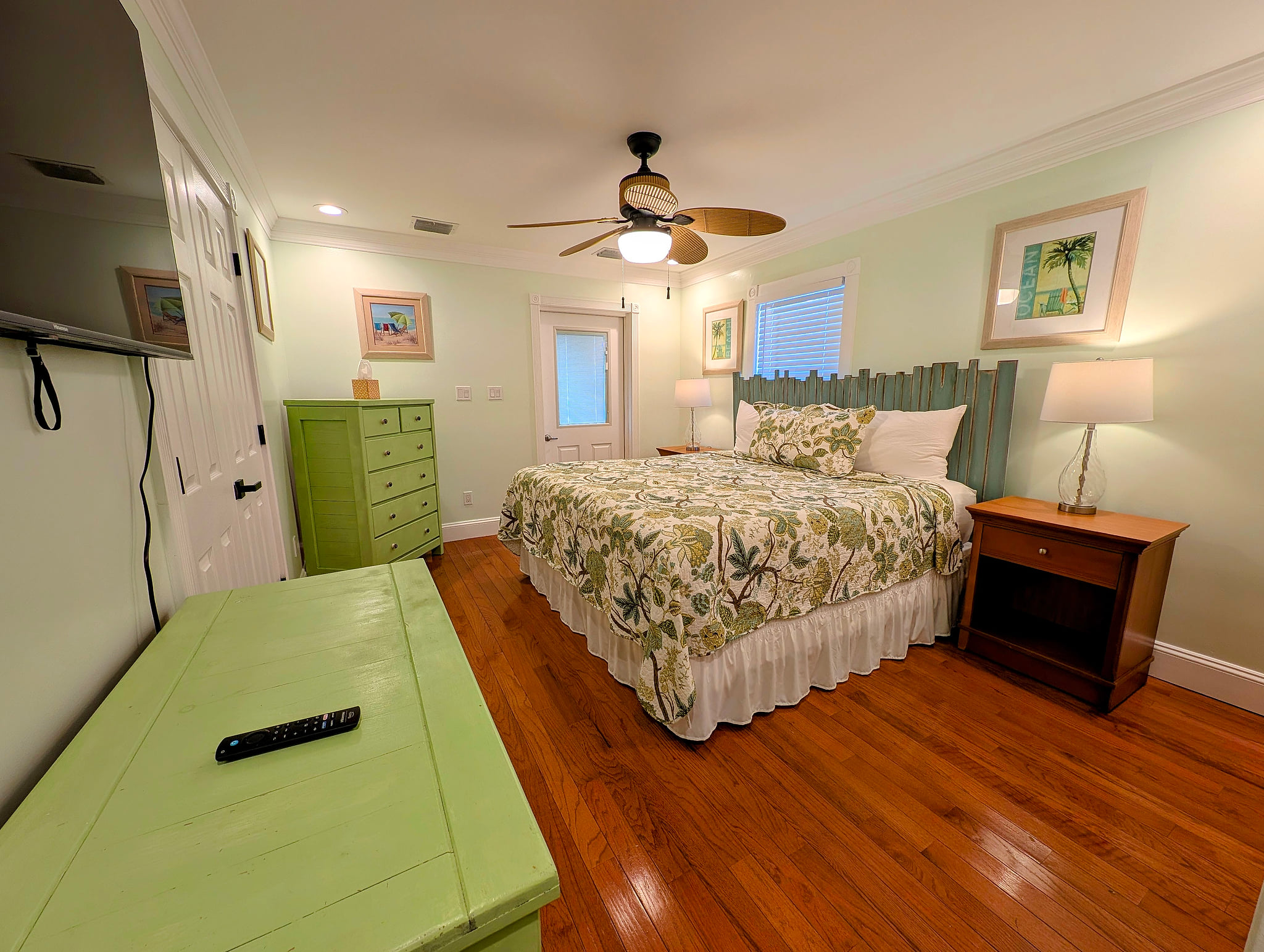 Master on suite coastal king bedroom with hardwood floors, 50 inch smart TV, ceiling fan & private porch access