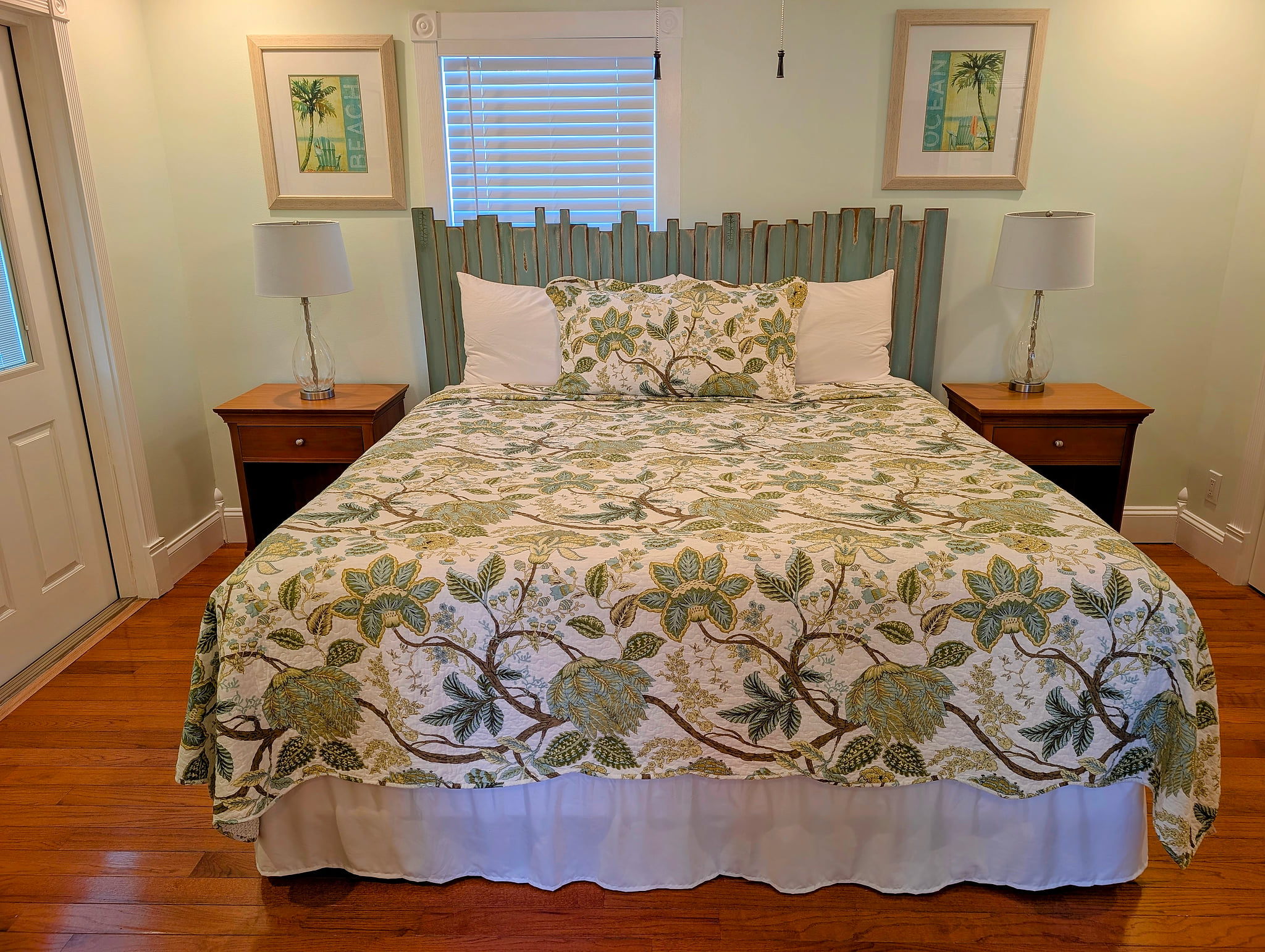 Serene coastal master bedroom with king bed, hardwood floors, and reading lamps