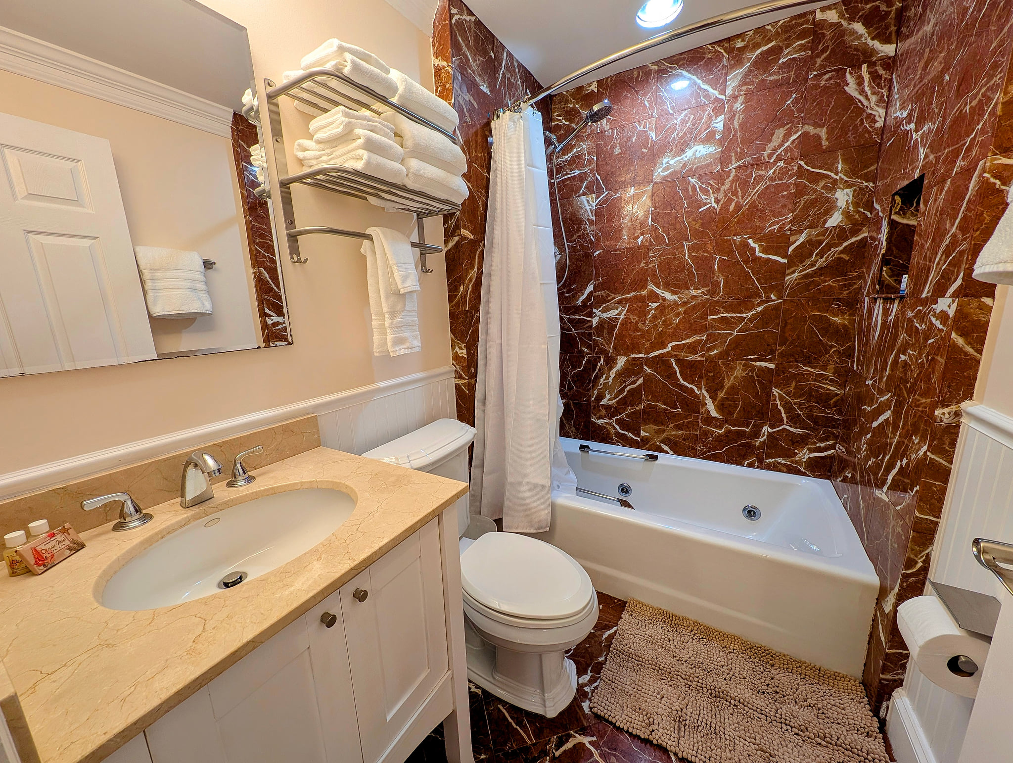 Second floor spa-like bathroom with marble surround, tub, and plush towels.