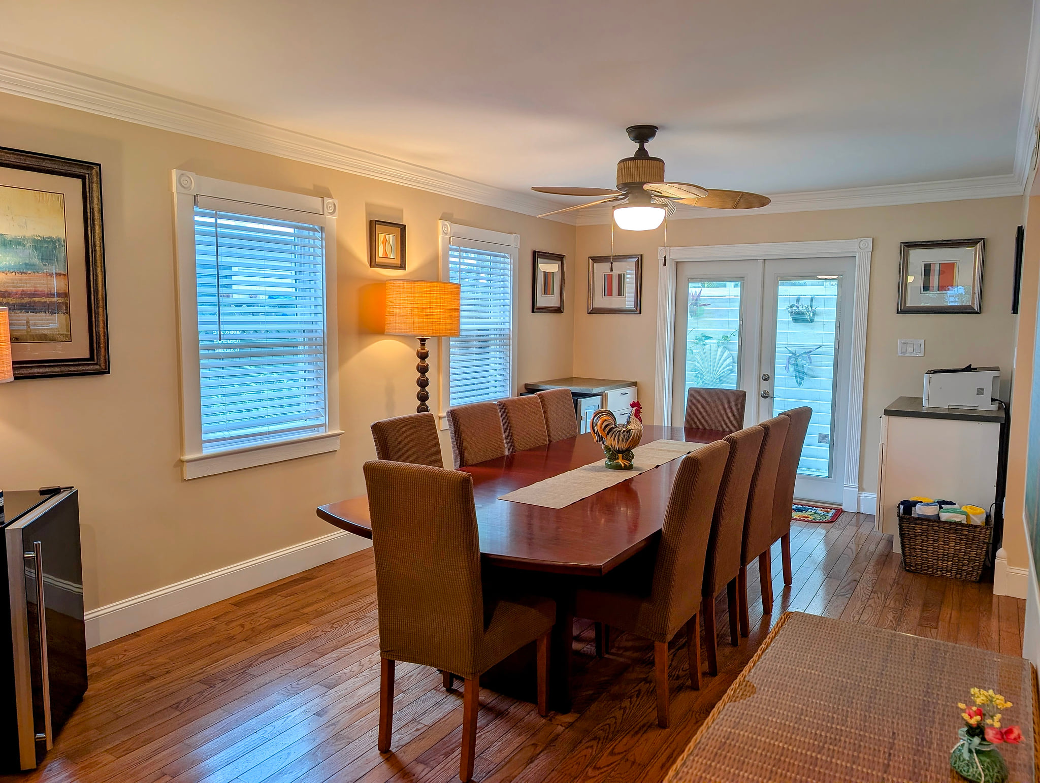 Bright dining room for 10 with hardwoods, fan, and patio access