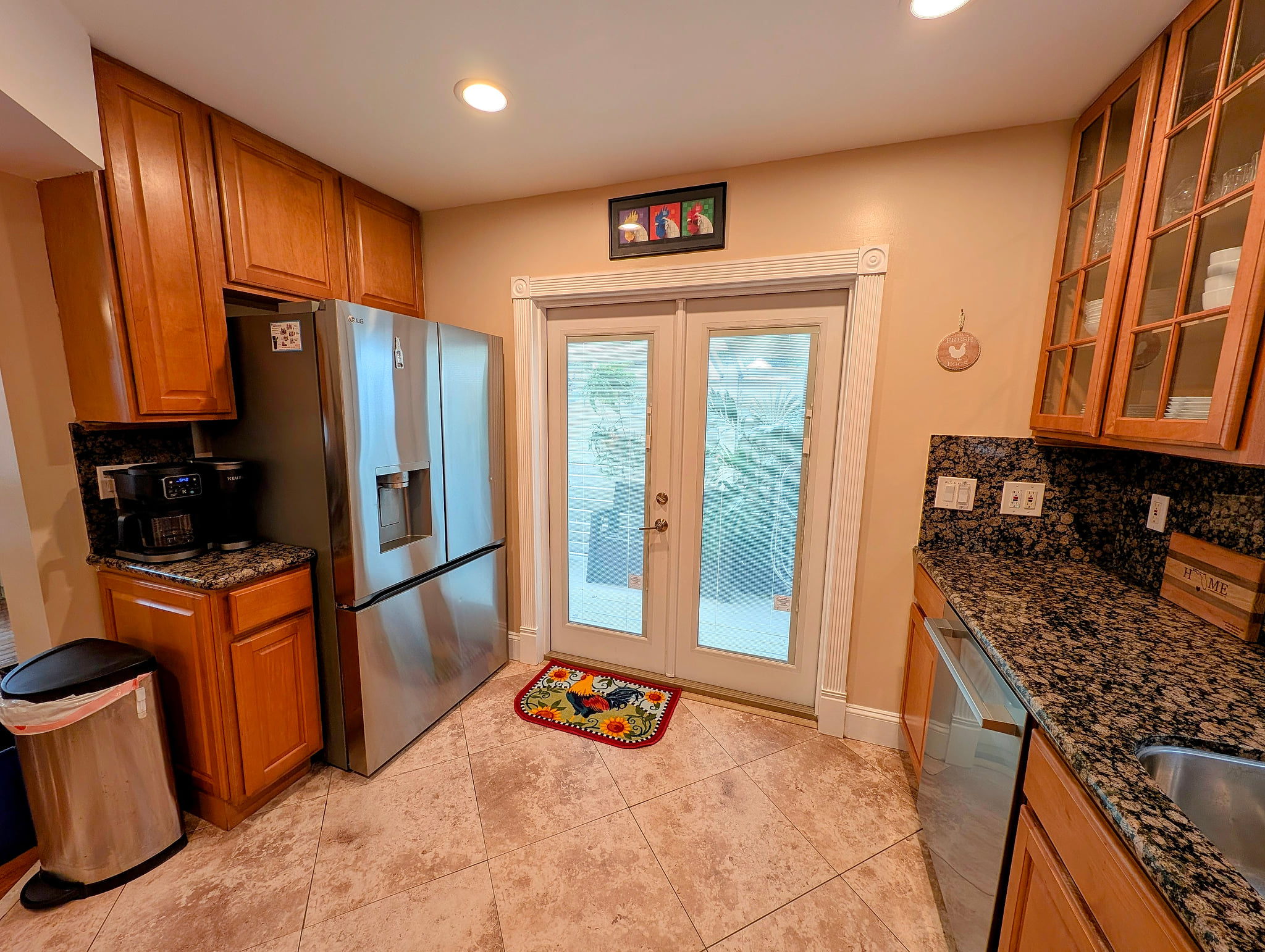Bright kitchen with granite, coffee bar, stainless fridge, dishwasher & patio access