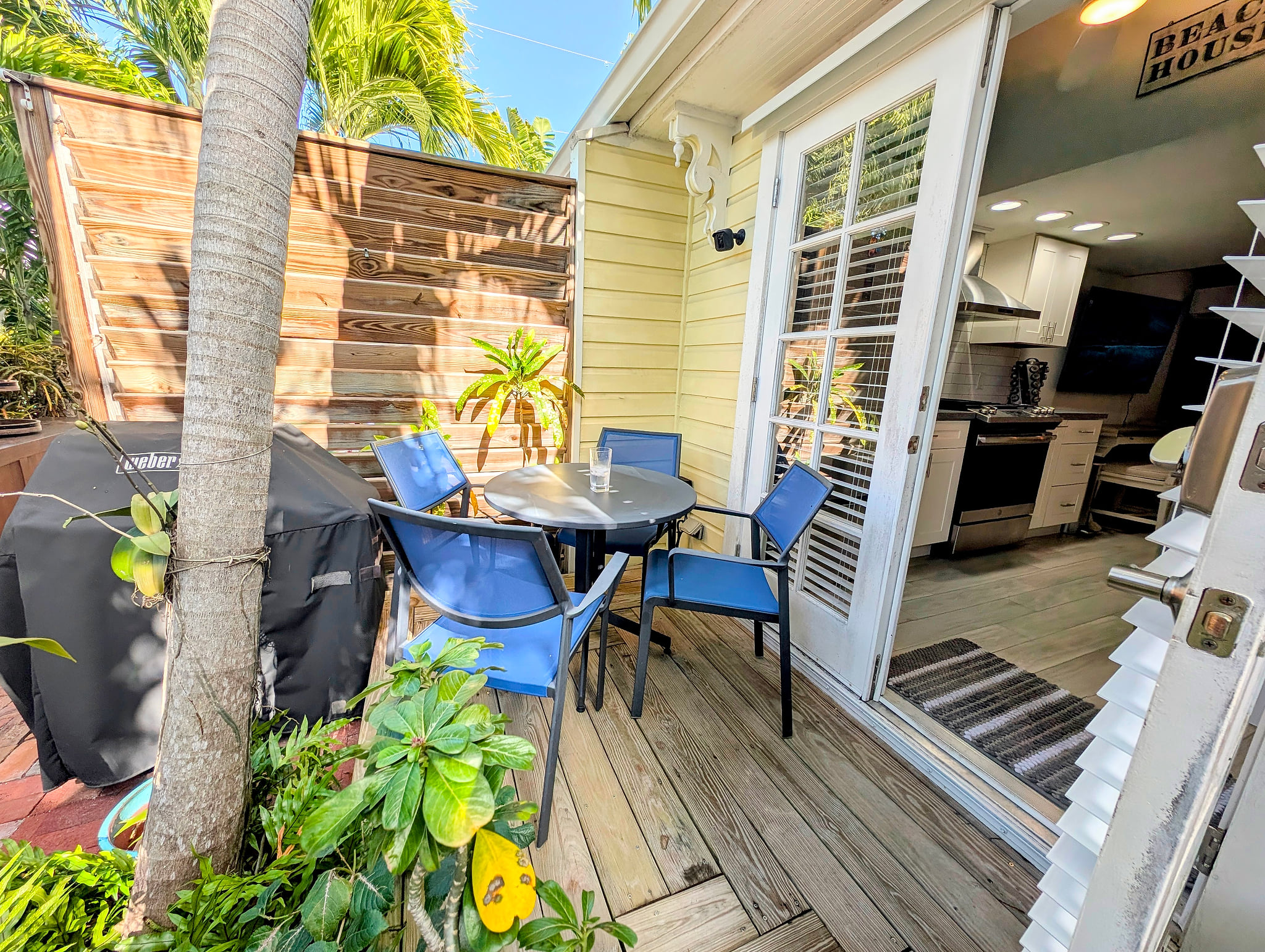 Tropical patio with grill, seating for four, steps from a modern kitchen