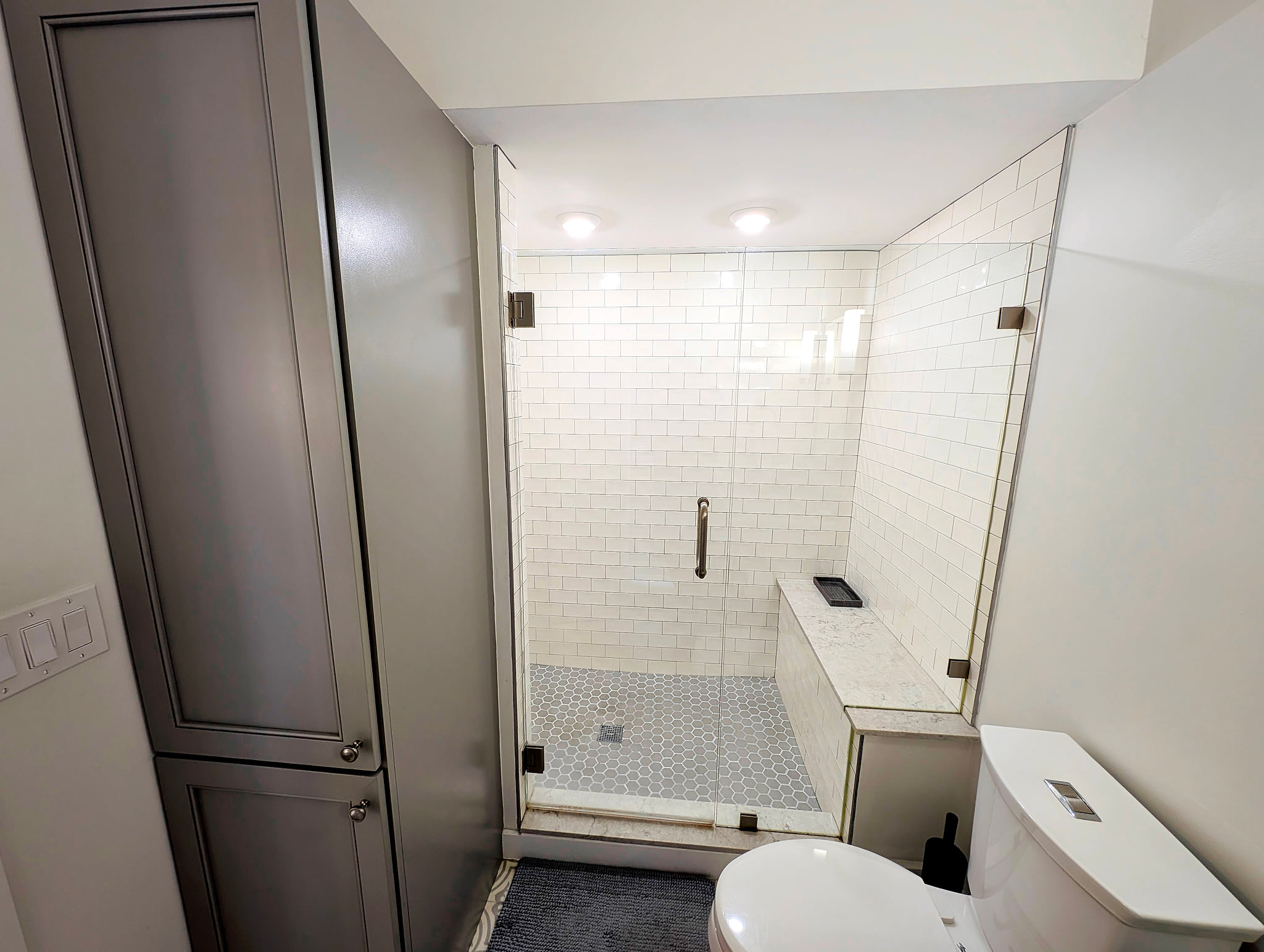 Sleek bath with frameless walk-in shower, bench, and subway tile Beach House Modern Old Town Studio Near Duval