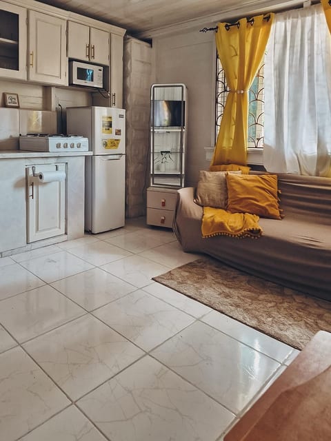 This is a comfortable room, equipped with the amenities for relaxation, such as a comfortable sofa, a smart TV set, air conditioner, a computer desk and a chair.  The room also has  a microwave, a fridge, a stove, a kettle, and cooking utensils. 