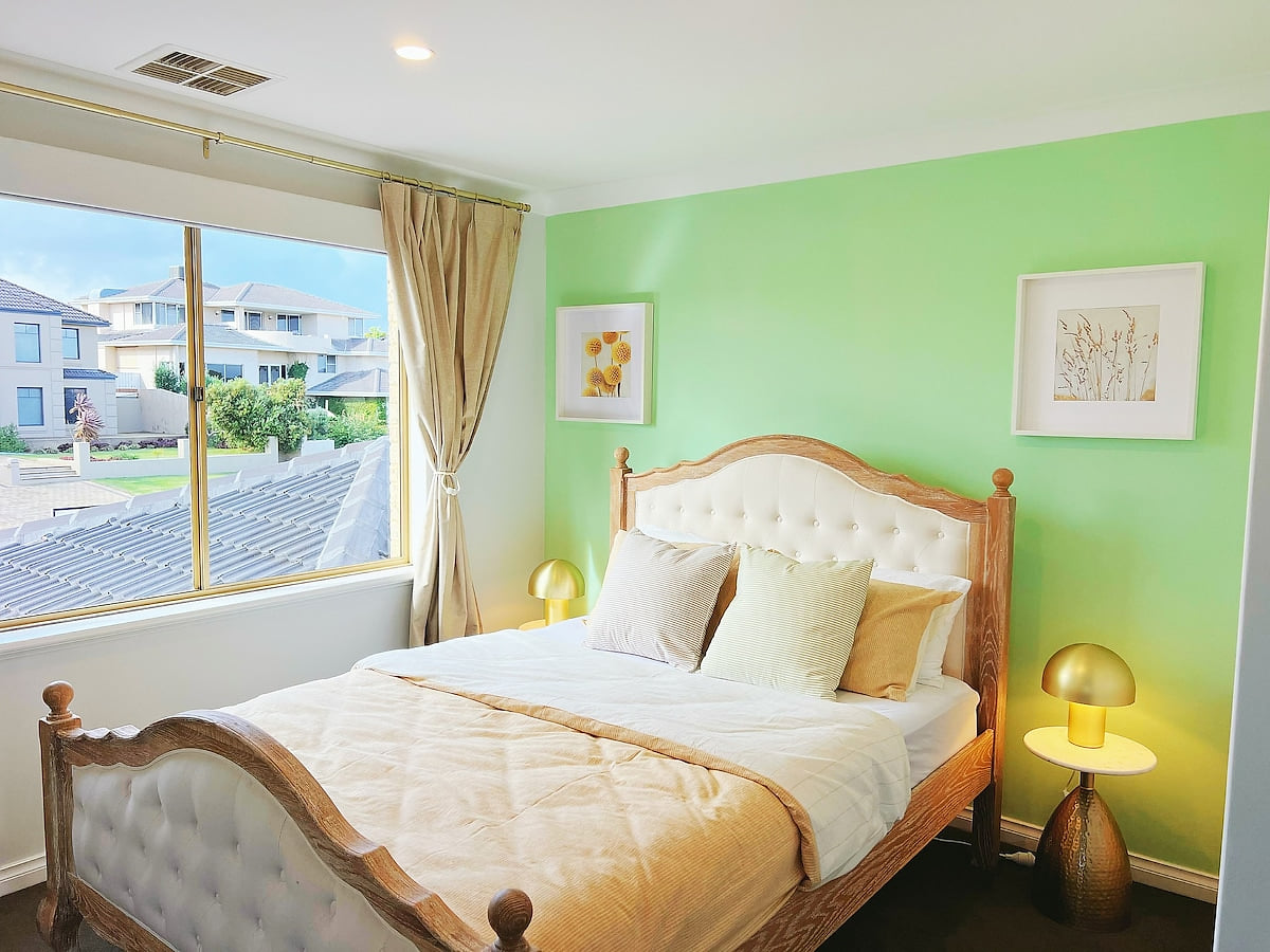 This charming bedroom offers a lovely view of the front garden. It features a very comfortable queen-sized bed and a convenient built-in wardrobe (BIR), providing both comfort and practical storage.
