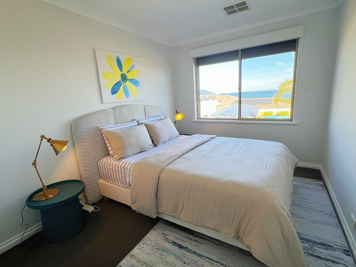 On the First floor, Bedroom 3 offers a serene escape with its captivating palm tree and ocean theme. Sink into the comfort of a queen-size bed and feel completely at one with nature, surrounded by decor that evokes the beauty of the seaside