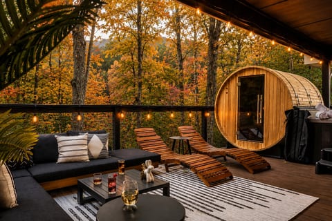 Unwind on the deck surrounded by vibrant fall colors, cozy seating, and a private sauna with peaceful mountain views.