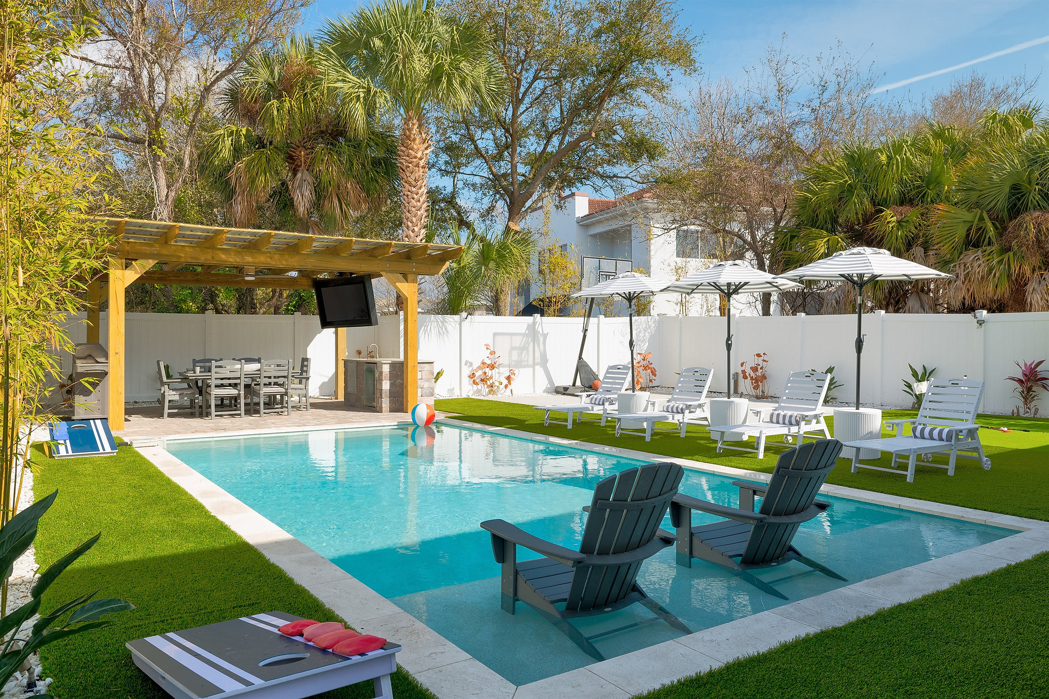 Your private backyard oasis features a sparkling pool, shaded pergola lounge, and outdoor kitchen — perfect for relaxing afternoons and evening gatherings.