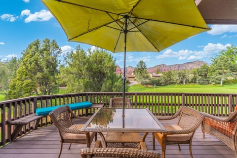 Spacious private deck with a dining table and shaded umbrella. Overlooking a lush green golf course with stunning views of Sedona's iconic red rocks, it’s the perfect spot for morning coffee or sunset drinks.