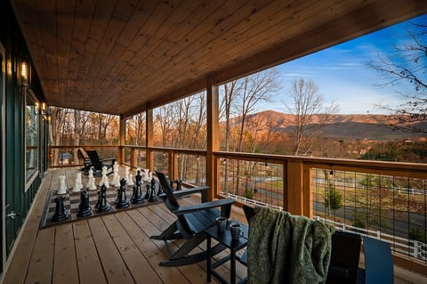 Covered deck with giant chess set, rocking chairs, and Smoky Mountain views. Grab your morning coffee and settle in because you won't want to leave this spot.