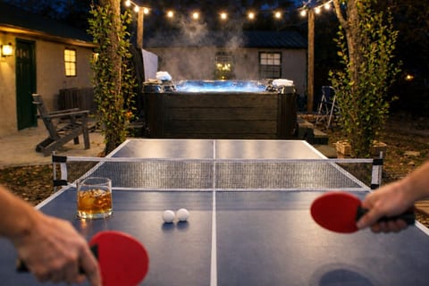 Game night, upgraded — ping pong under the string lights with the hot tub just steps away.