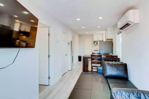 Open Concept Kitchen with Full Fridge/Freezer, Range Stovetop (Stove Only, NO OVEN), Air Conditioning (AC), Dining Table, 55" Wall Mounted Roku TV, Sofa (converts flat to full size bed) and Common Area Half-Bath