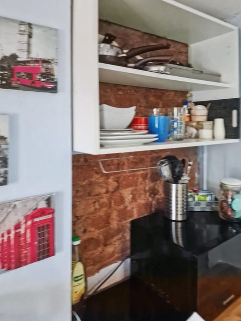 Cozy kitchenette with exposed brick, open shelves & essentials