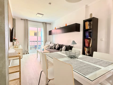 Bright modern living-dining space with balcony doors and comfy sofa
