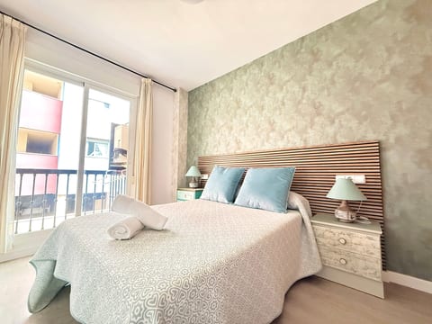 Bright bedroom with balcony doors, queen bed and chic accent wall