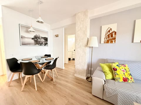 Bright modern lounge with glass dining table and cozy sofa accents.