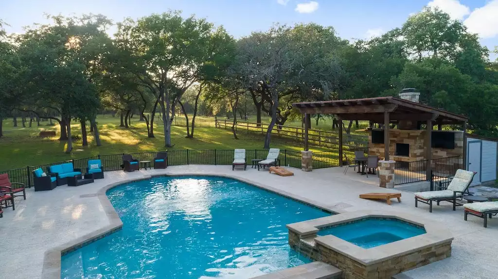 The pool area has plenty of comfortable seating to soak up the sun. The pool area has plenty of comfortable seating to soak up the sun. - Main House at Whispering Oaks Estate - Dripping Springs