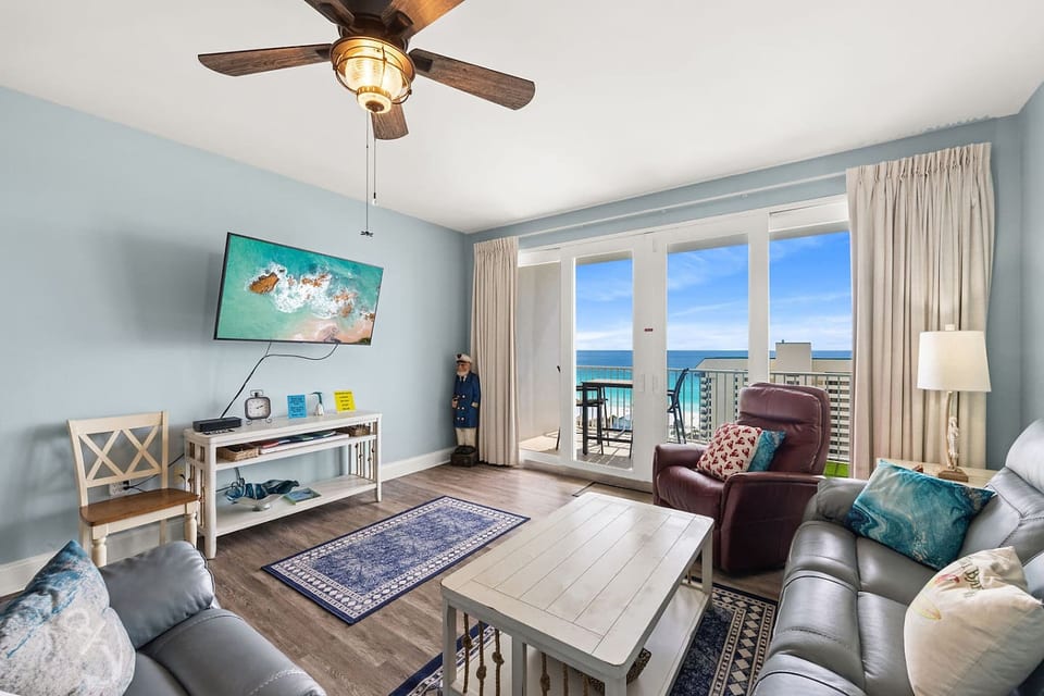 Relaxing living area with plush seating, Smart TV, and a private balcony showcasing breathtaking Gulf views.